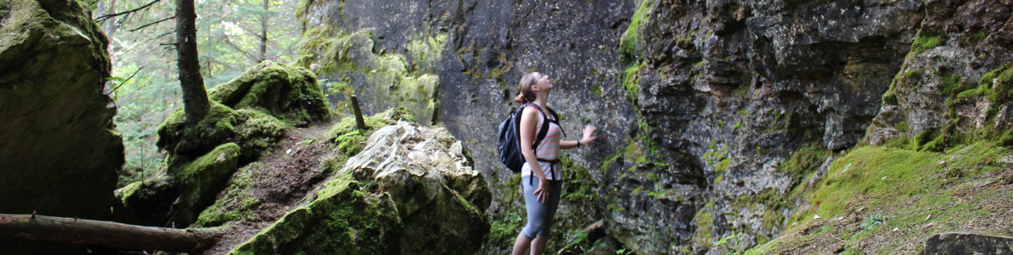 Woman looing up at the cliffs on a hiking trail in the Clearwater Lake caves