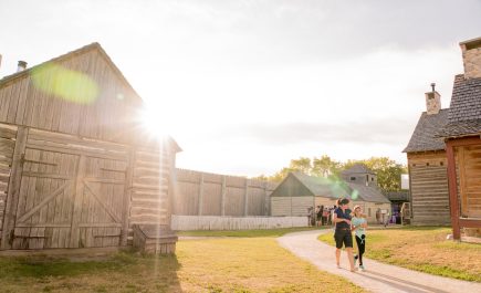 Two people walking along the path through the buildings at Fort Gibraltar.